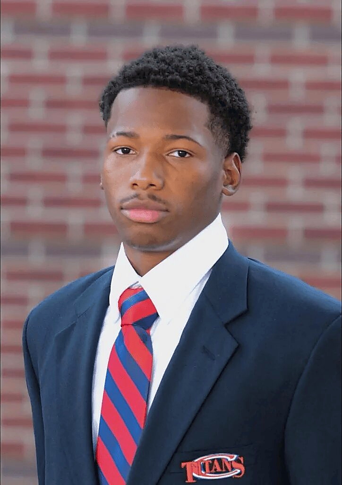 Karmelo Anthony — Titans school portrait, navy blazer, red and blue striped tie